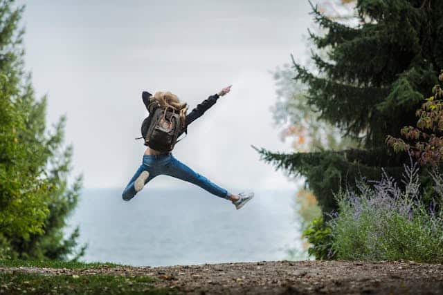 A Person Jumping Up In The Air With Joy And Happiness.