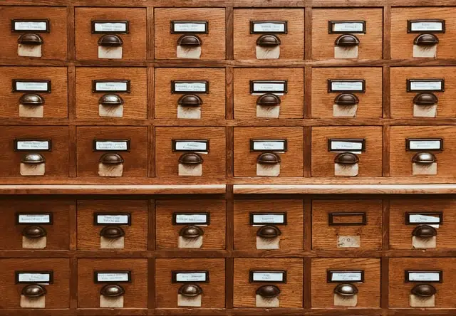 Color-coded cardboard boxes arranged in size order on warehouse shelves, illustrating the concept of sorting