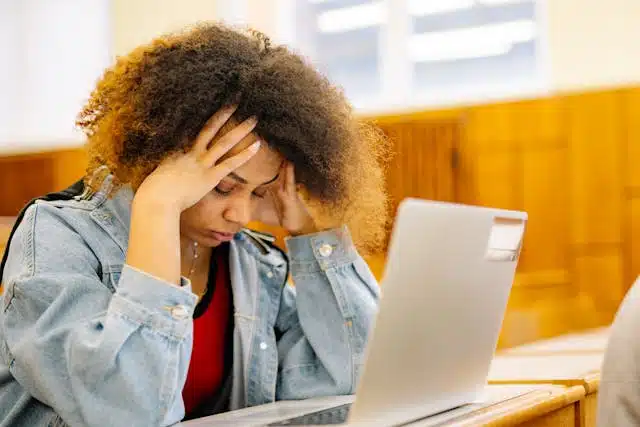 A stressed student staring at a laptop after her code submission failed on the university grading portal